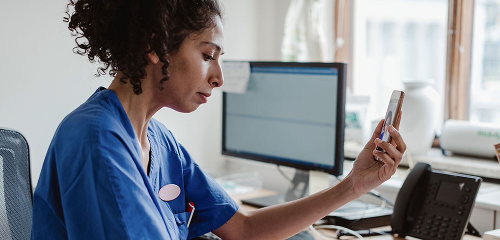 Nurse working on finances with mobile app